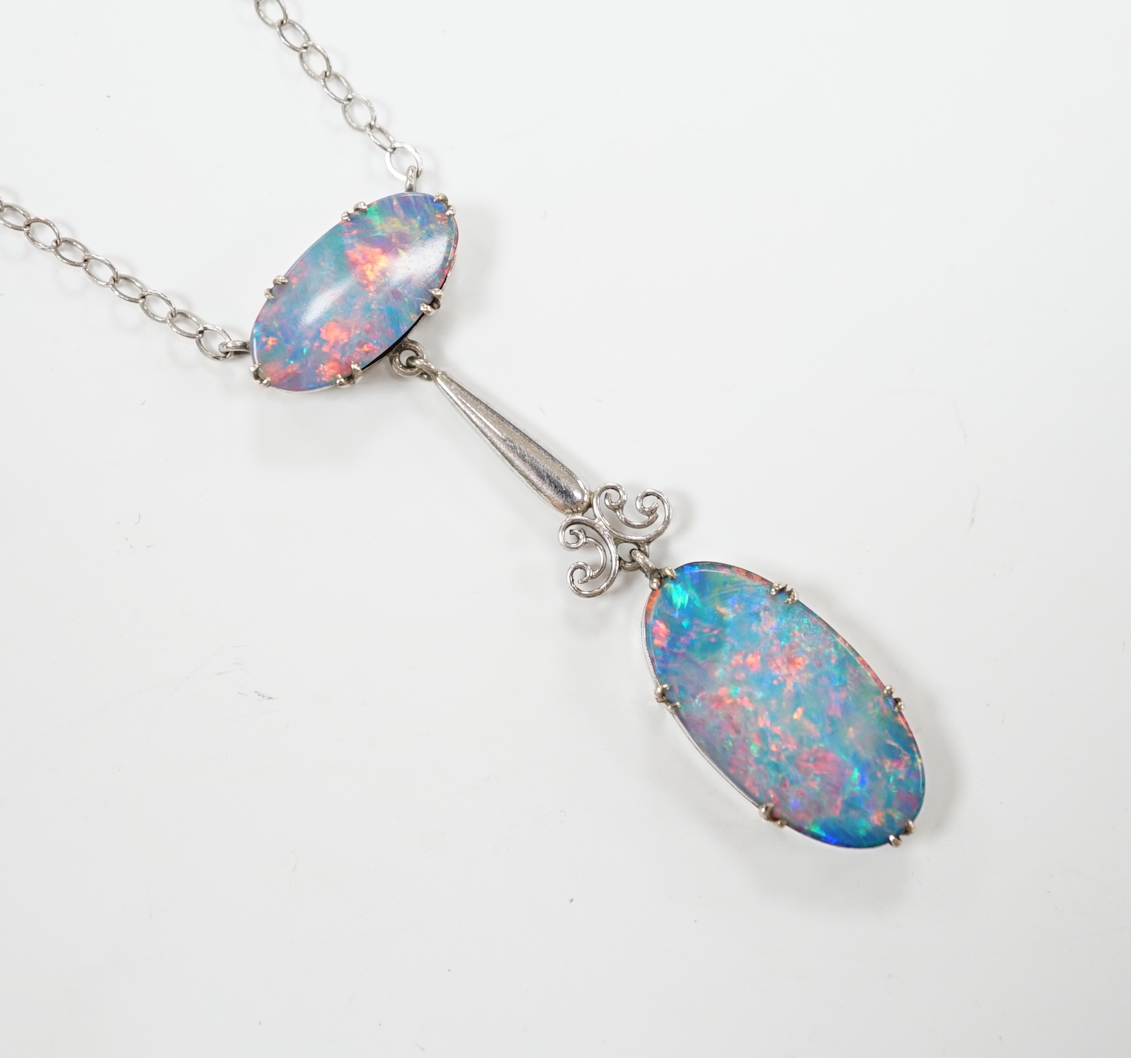 A 1920's style 9ct white metal and two stone black opal doublet set drop pendant necklace, overall 58cm, gross weight 4 grams.